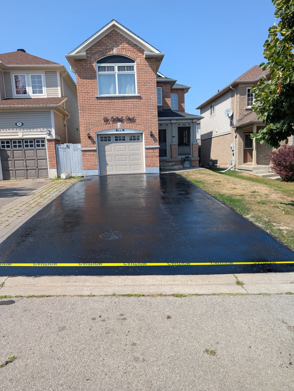 Wet, freshly sealed asphalt driveway